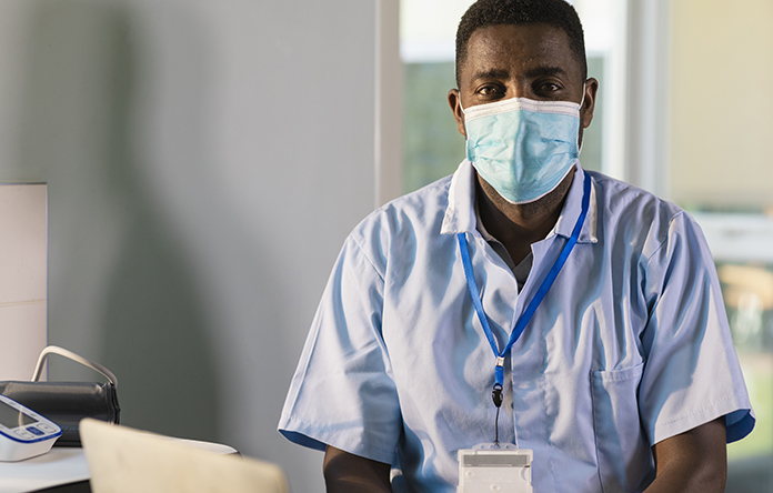 Male NHS worker wearing a face mask.